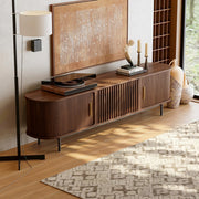 Wooden mid century tv stand with decorative items in a living room setting